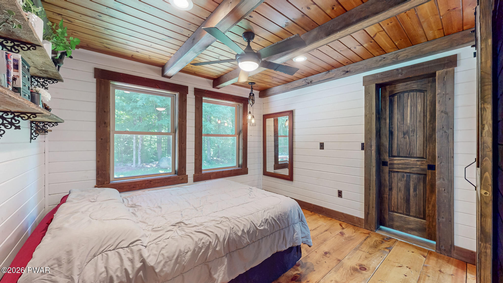 149 Sheards Road Milanville, PA 18443 - Photo 29 of 57 a spacious bedroom with a large bed and a chandelier