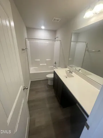 a bathroom with a double vanity sink a toilet and a bathtub