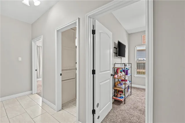 a view of a hallway with workspace and living room