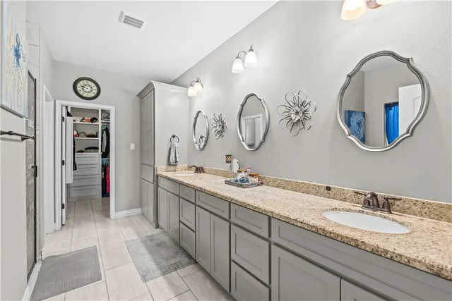 a spacious bathroom with a granite countertop double vanity sink and a mirror
