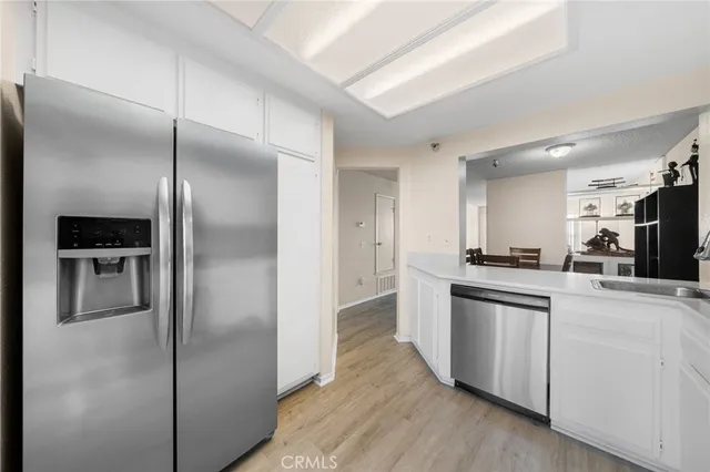 a kitchen with stainless steel appliances kitchen island granite countertop a refrigerator and a sink