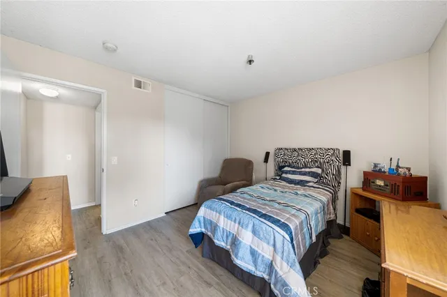 a bedroom with two beds and a potted plant on the dresser