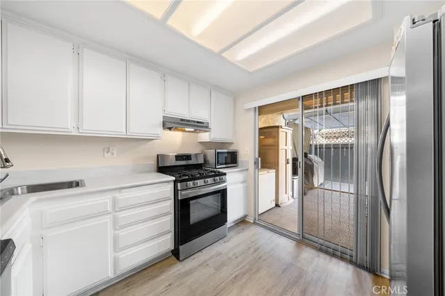 a kitchen with stainless steel appliances granite countertop a refrigerator and a stove top oven