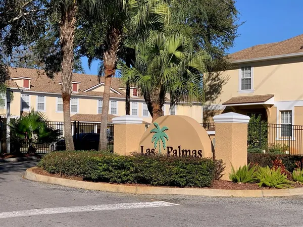 a front view of a house with a garden and a tree
