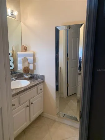 a bathroom with a granite countertop sink and a mirror