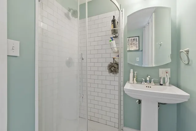 a bathroom with a sink a mirror and shower