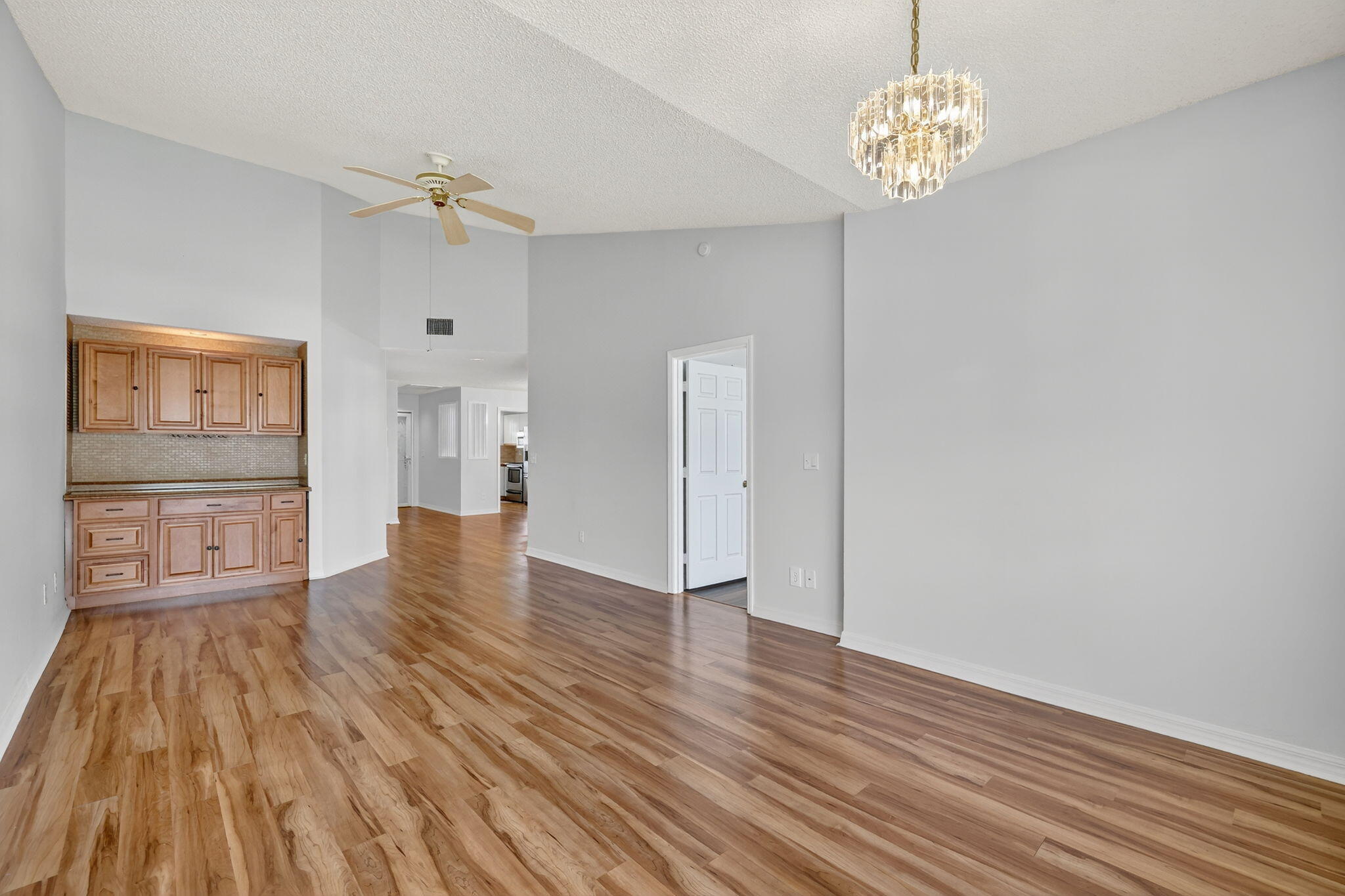 6101 Southeast Landing Way, Unit 11 Stuart, FL 34997 - Photo 14 of 55 a view of empty room with wooden floor and kitchen view