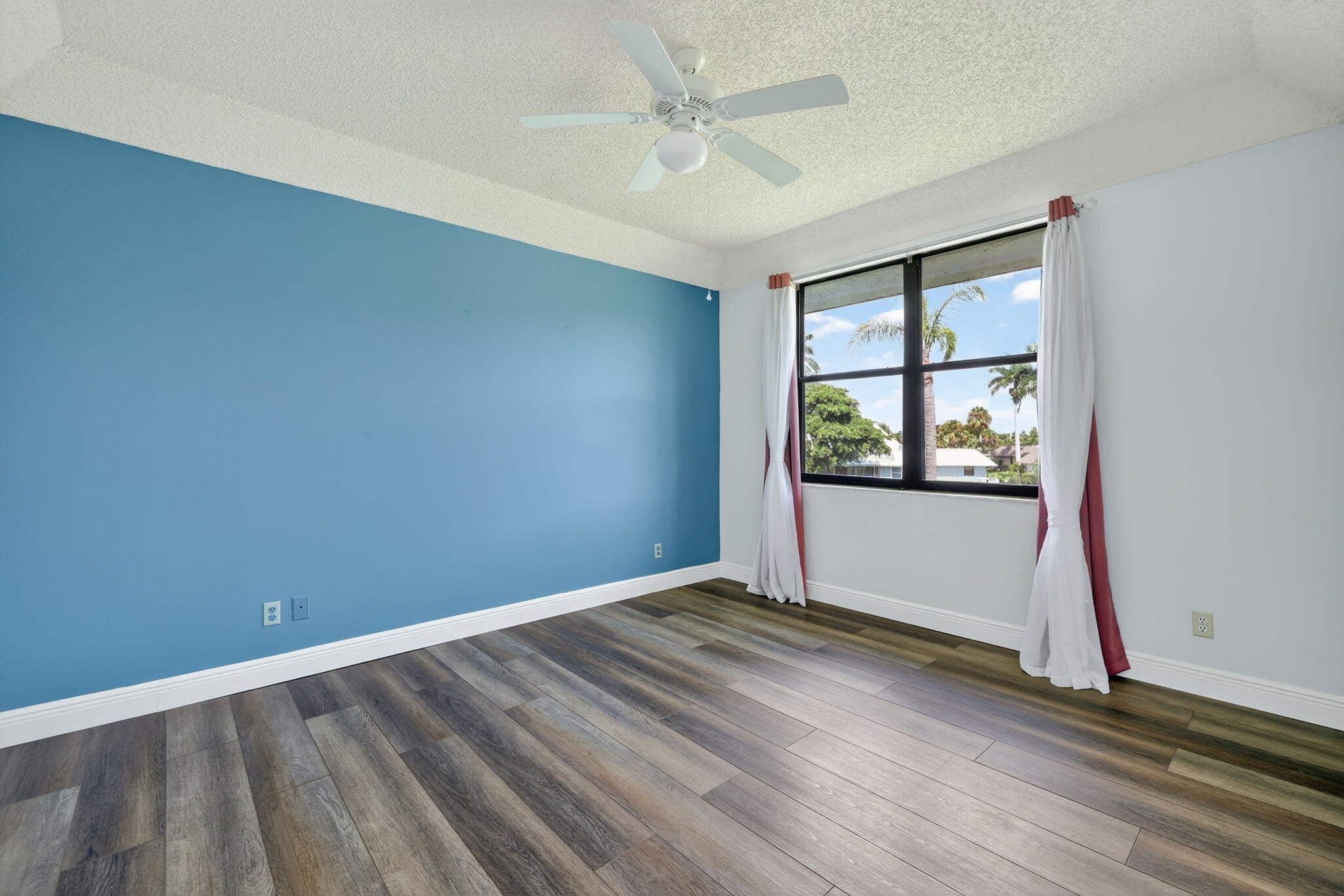 6101 Southeast Landing Way, Unit 11 Stuart, FL 34997 - Photo 16 of 55 an empty room with wooden floor and windows