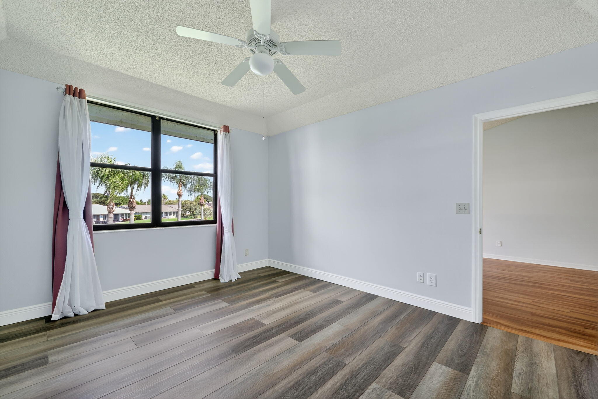 6101 Southeast Landing Way, Unit 11 Stuart, FL 34997 - Photo 19 of 55 an empty room with wooden floor and windows