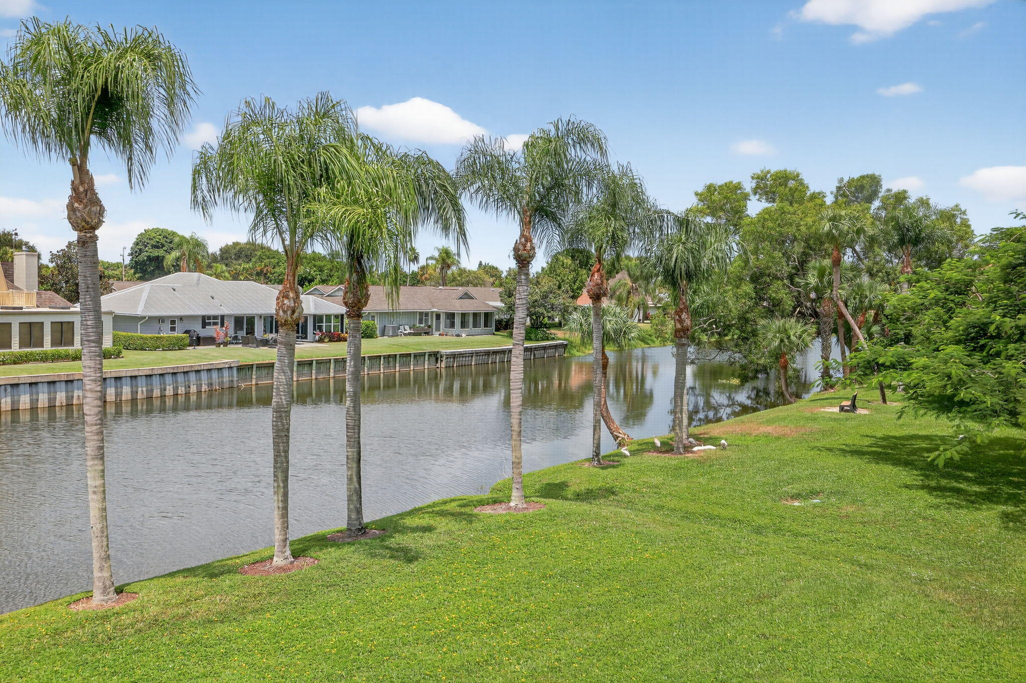 6101 Southeast Landing Way, Unit 11 Stuart, FL 34997 - Photo 53 of 55 a view of a deck with a big yard and palm trees