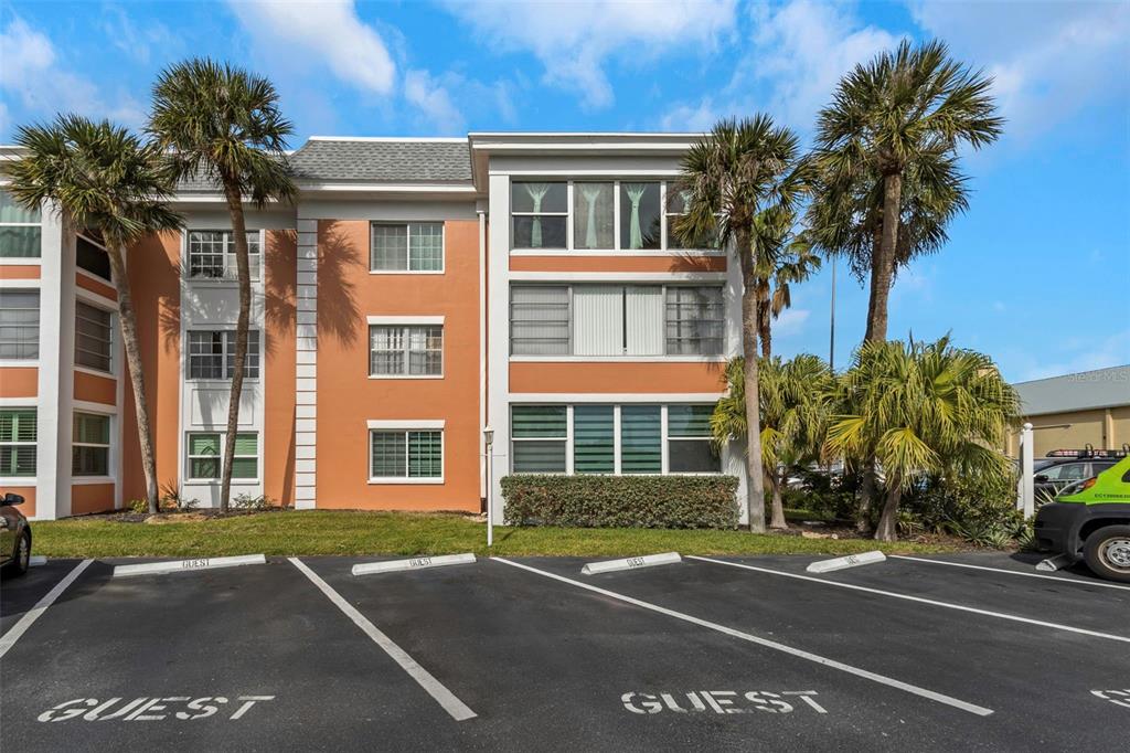 1900 68th Street North, Unit 110 St. Petersburg, FL 33710 - Photo 2 of 48 a front view of a building with a yard and palm trees