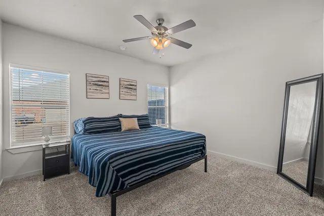 a bedroom with a bed and a large window
