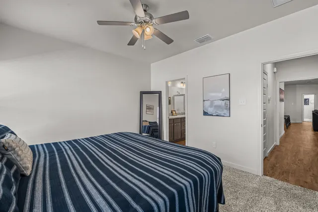 a bedroom with a large bed and a chandelier