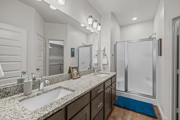 a bathroom with a granite countertop sink a mirror and shower