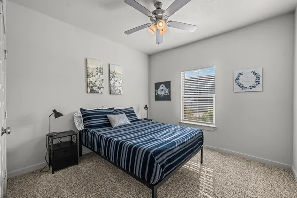 a bedroom with a bed lamp and a window