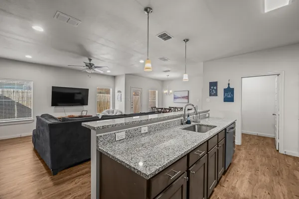 a kitchen with granite countertop a sink and a stove top oven