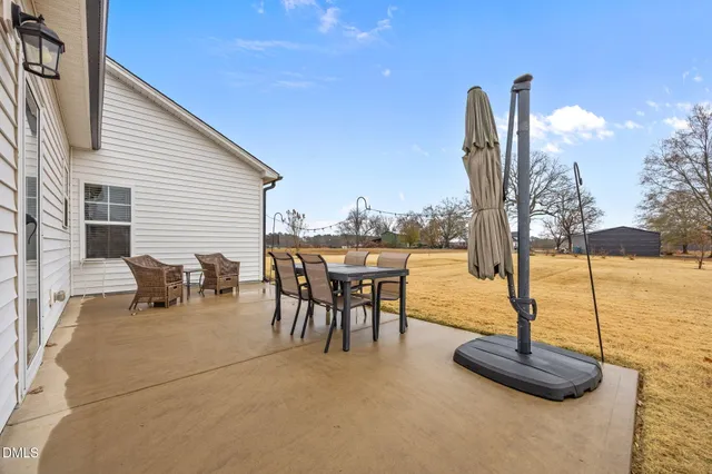 a view of a house with patio and a yard