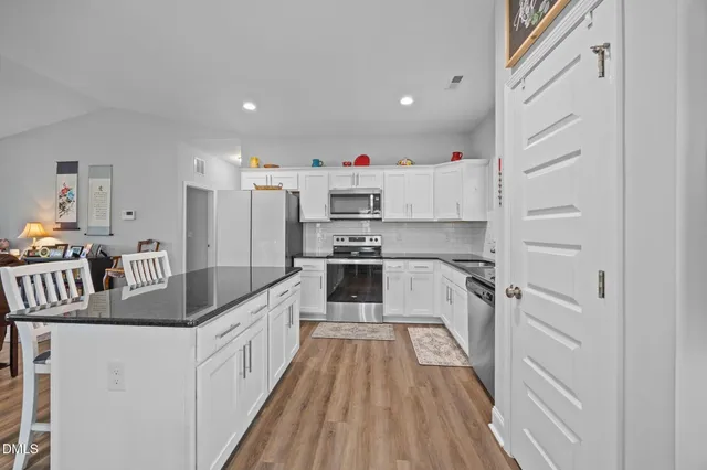 a kitchen with kitchen island a counter top space a sink and cabinets