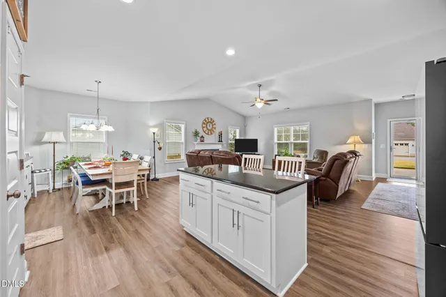 a living room with furniture a dining table and chairs with wooden floor