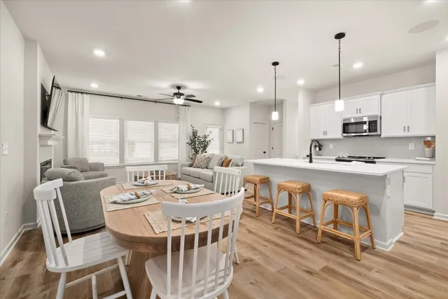 a large kitchen with kitchen island a stove a sink a dining table and chairs