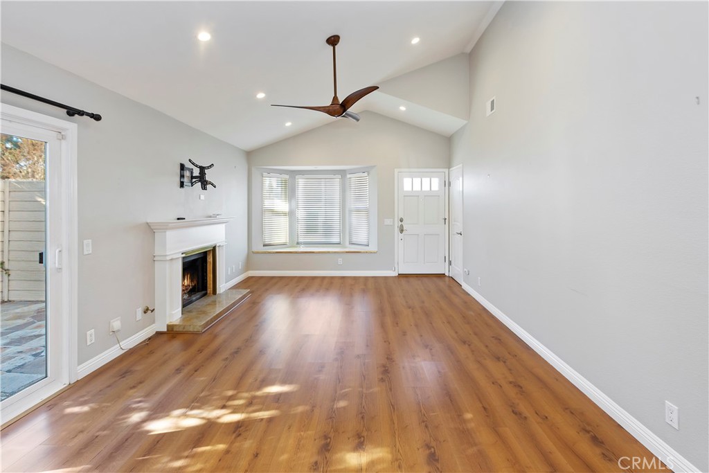 38 Racing Wind Irvine, CA 92614 - Photo 4 of 19 an empty room with wooden floor fireplace and windows