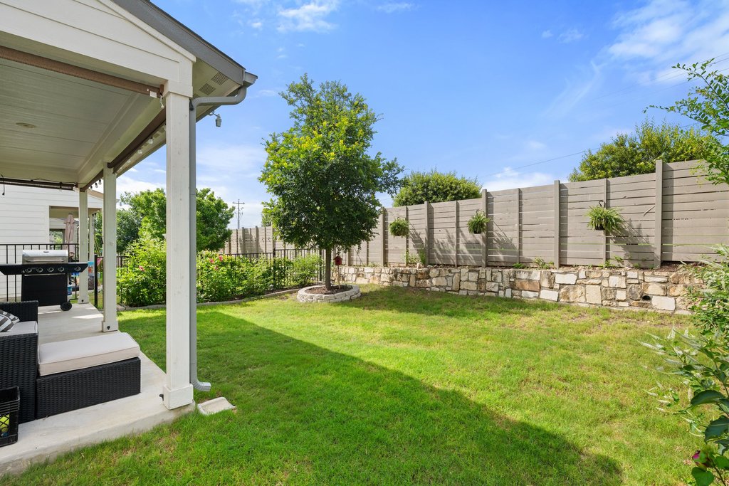 7403 Travertine Spring Drive, Unit 117 Austin, TX 78744 - Photo 6 of 37 A generous lawn and inviting covered patio offer ample outdoor living space.