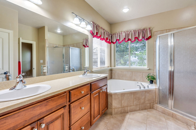 373 East Alexander Drive Elk Ridge, UT 84651 - Photo 19 of 69 Dual vanity with undermount sinks, a built-in corner soaking tub, a separate glass-enclosed shower, and tile flooring