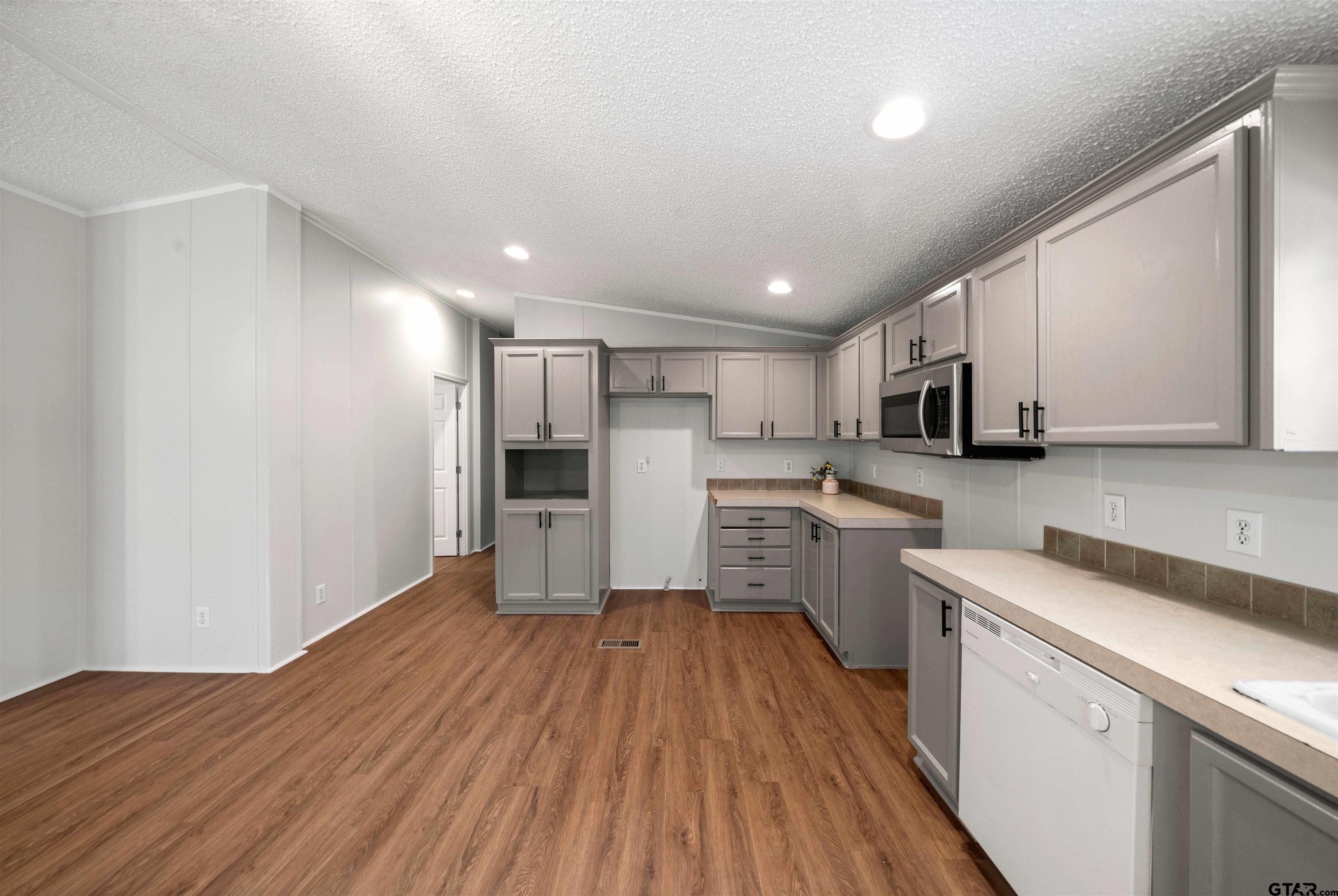 10490 Peterson Tyler, TX 75708 - Photo 11 of 30 a kitchen with cabinets wooden floor and stainless steel appliances