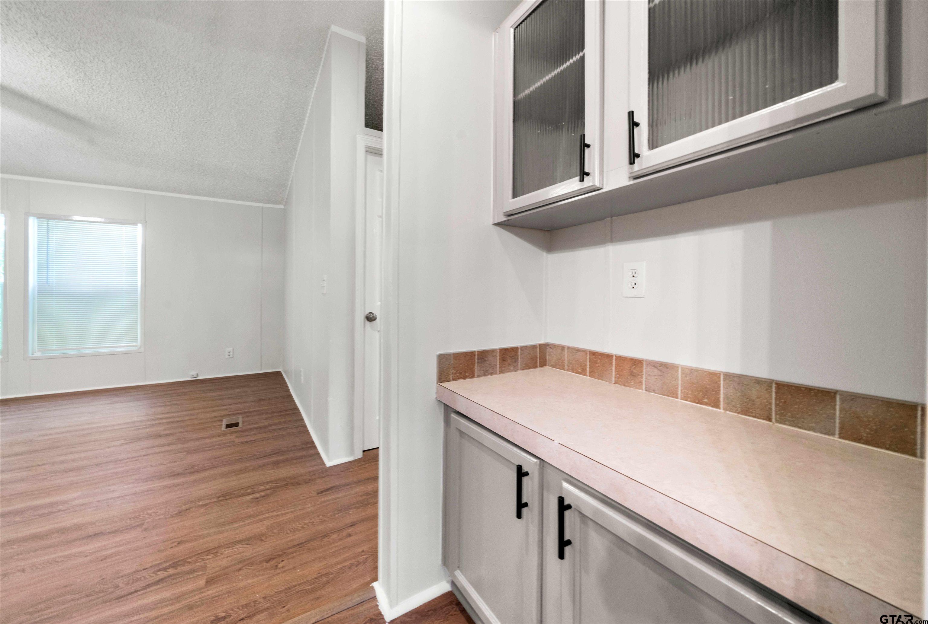 10490 Peterson Tyler, TX 75708 - Photo 13 of 30 a view of a kitchen with white cabinets and wooden floor