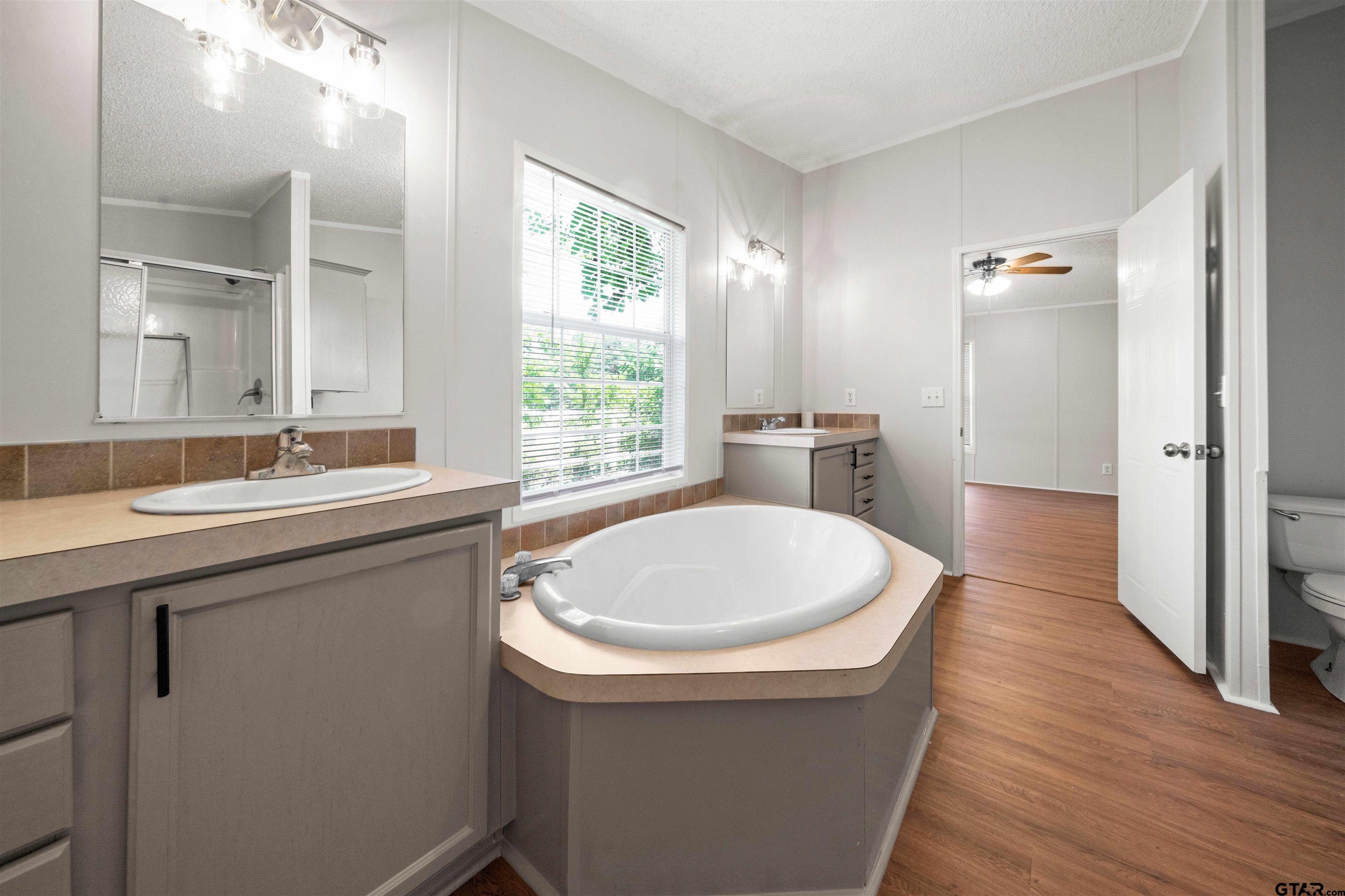 10490 Peterson Tyler, TX 75708 - Photo 27 of 30 a bathroom with a sink a bathtub a mirror and a window