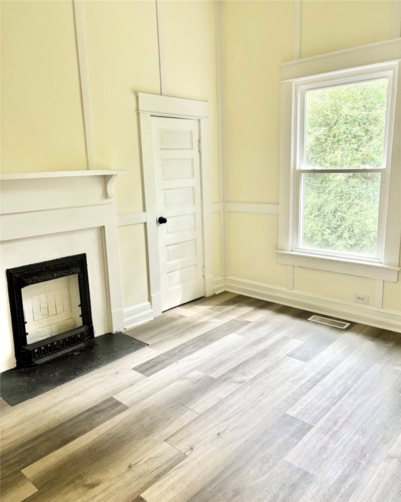 208 Hampton Street Iva, SC 29655 - Photo 13 of 19 This bright space features sleek flooring and a classic fireplace, creating a warm, inviting atmosphere.