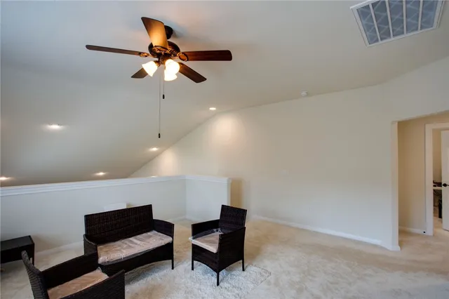 a living room with furniture and a ceiling fan
