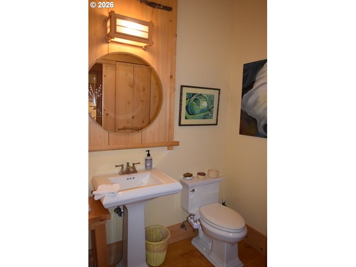 97137 North Bank Rogue River Road Gold Beach, OR 97444 - Photo 19 of 40 a bathroom with a toilet sink and mirror