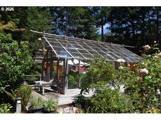 97137 North Bank Rogue River Road Gold Beach, OR 97444 - Photo 20 of 40 a view of a patio with table and chairs and potted plants
