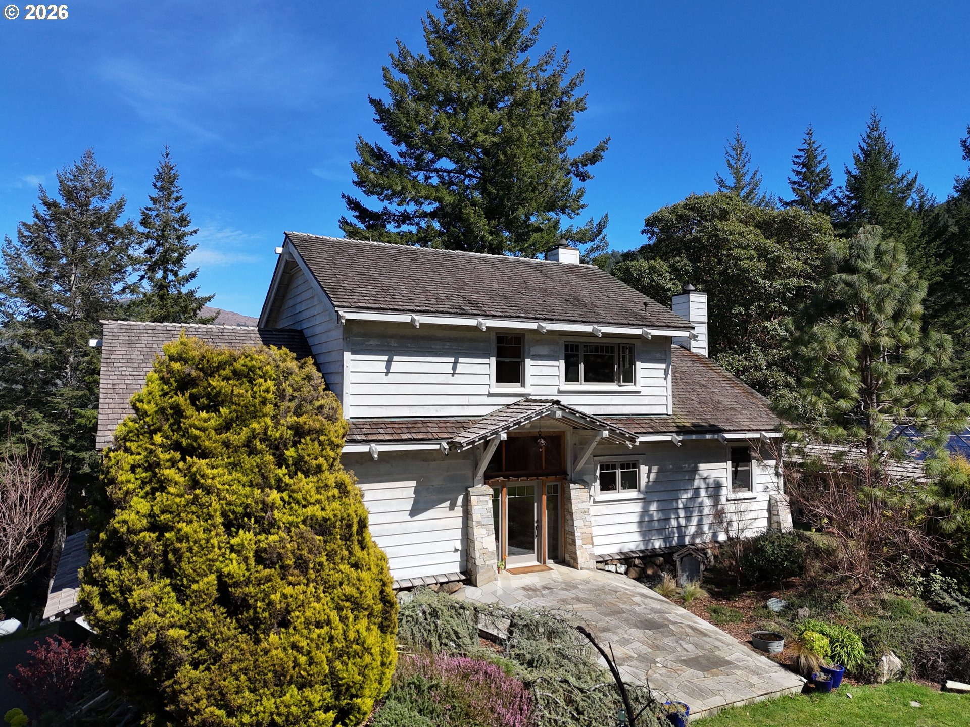 97137 North Bank Rogue River Road Gold Beach, OR 97444 - Photo 2 of 40 a front view of a house with a yard