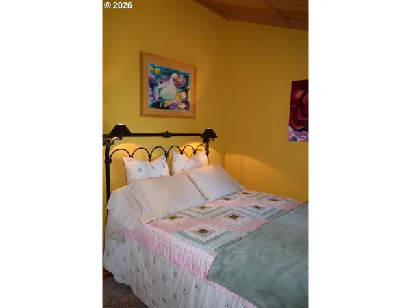 a bedroom with a bed and painting on the wall