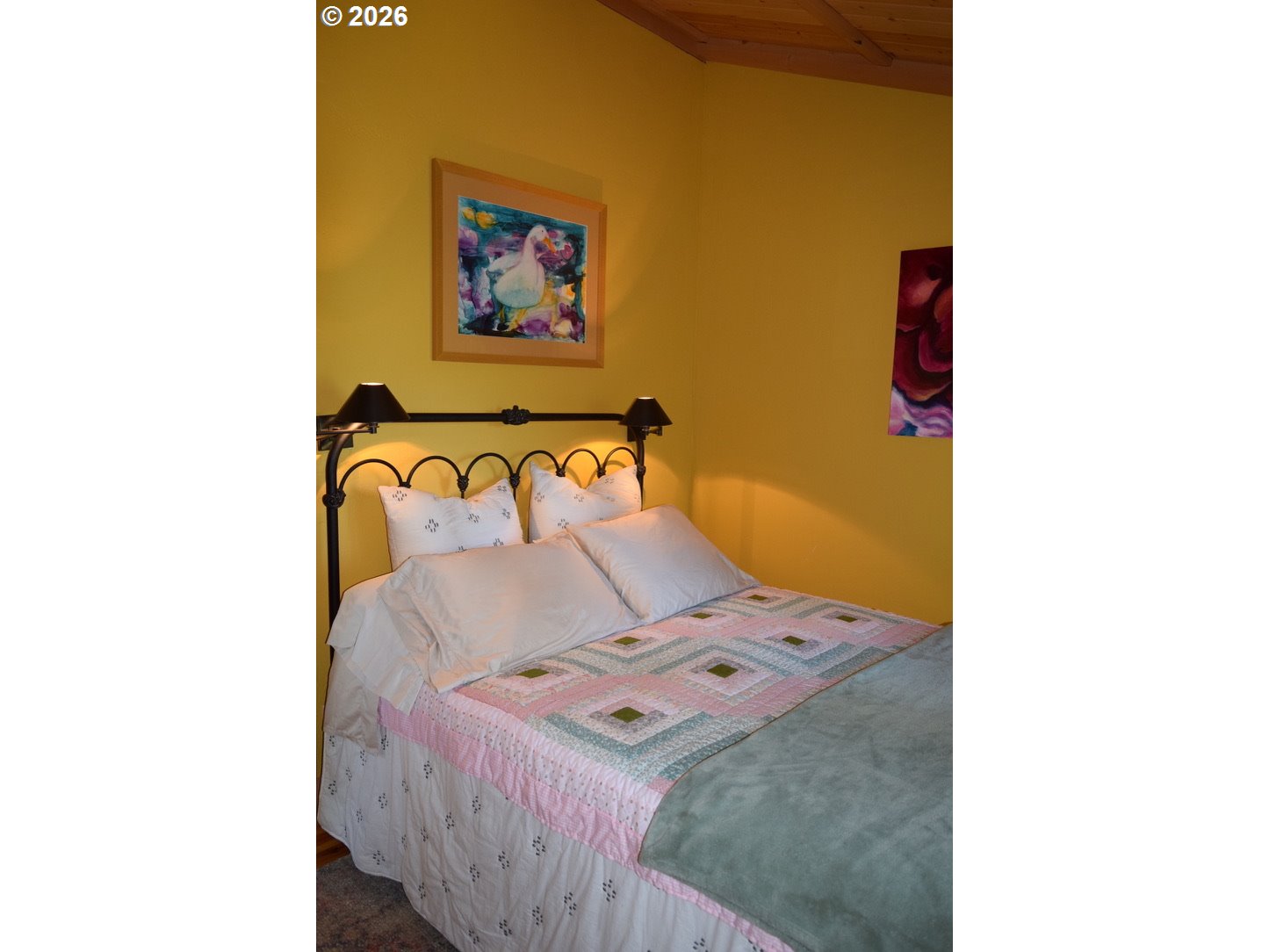 97137 North Bank Rogue River Road Gold Beach, OR 97444 - Photo 25 of 40 a bedroom with a bed and painting on the wall