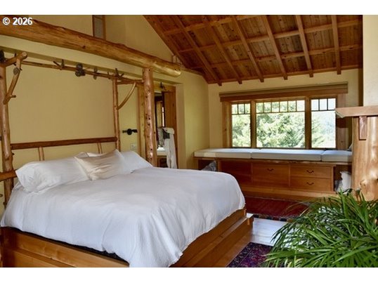 97137 North Bank Rogue River Road Gold Beach, OR 97444 - Photo 35 of 40 a bedroom with a bed and a window