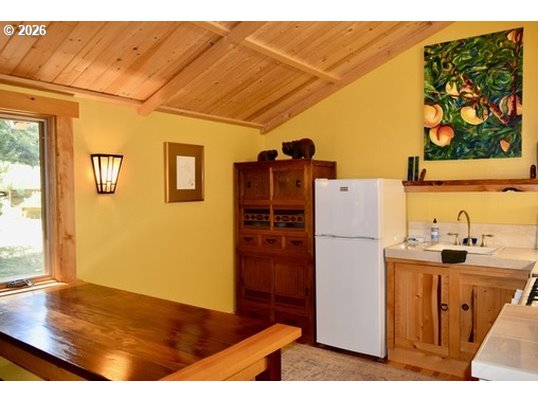 97137 North Bank Rogue River Road Gold Beach, OR 97444 - Photo 38 of 40 a kitchen with a refrigerator and a stove
