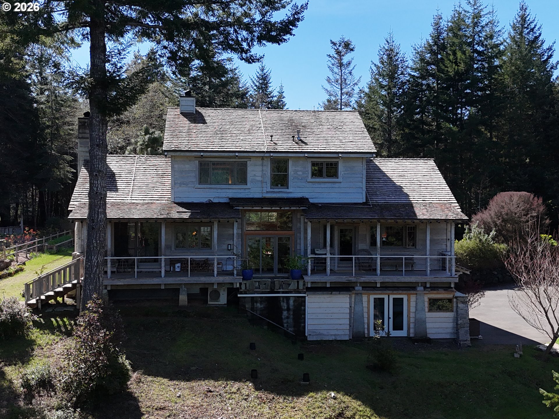 97137 North Bank Rogue River Road Gold Beach, OR 97444 - Photo 4 of 40 a front view of a house with a garden