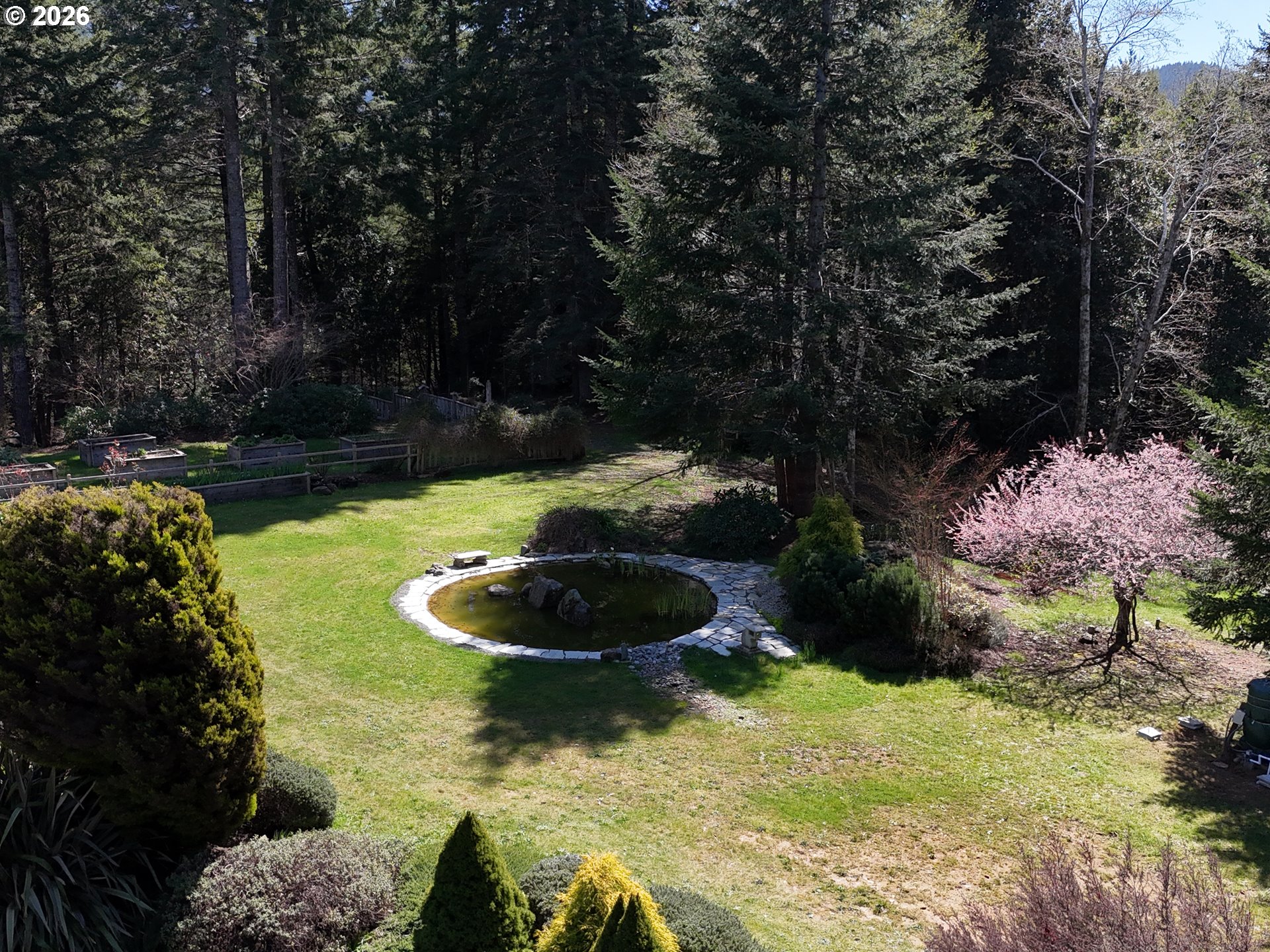97137 North Bank Rogue River Road Gold Beach, OR 97444 - Photo 5 of 40 a blue swimming pool with some plants and trees
