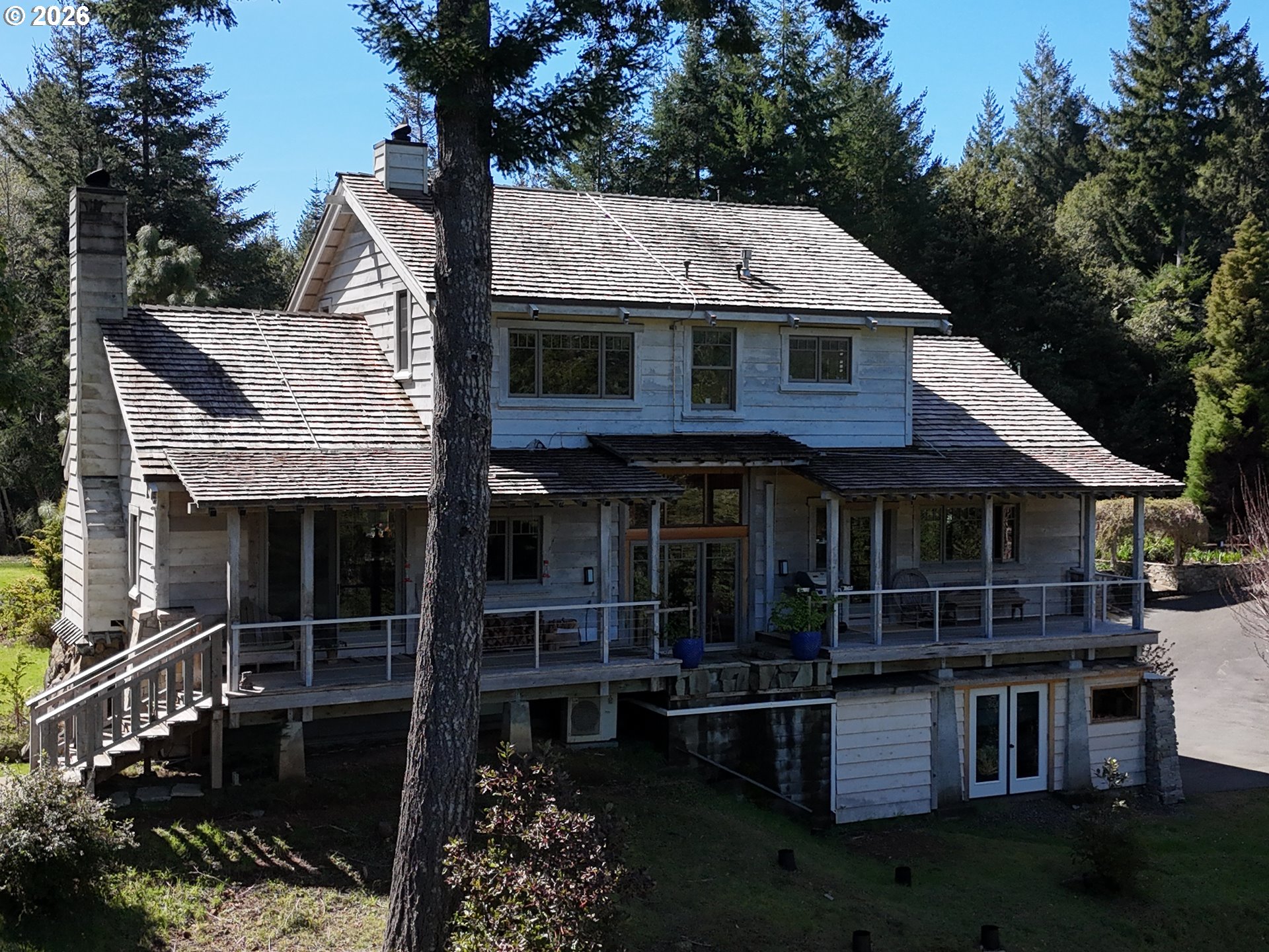97137 North Bank Rogue River Road Gold Beach, OR 97444 - Photo 6 of 40 a front view of a house with balcony