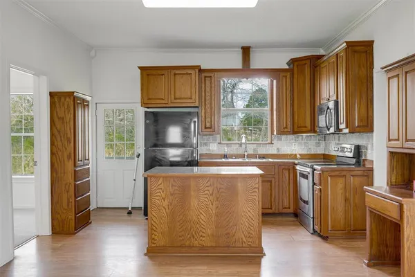 a kitchen with stainless steel appliances granite countertop a coffee maker a sink and a refrigerator