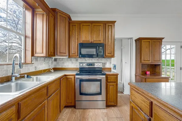a kitchen with stainless steel appliances granite countertop a stove a sink and a microwave