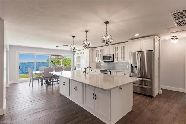 a large kitchen with stainless steel appliances granite countertop a large center island and a wooden floors