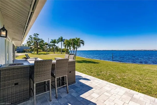 a kitchen with stainless steel appliances granite countertop a table chairs and a wooden floor