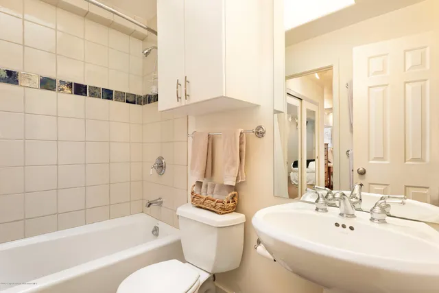 a bathroom with a bathtub a sink and a large mirror