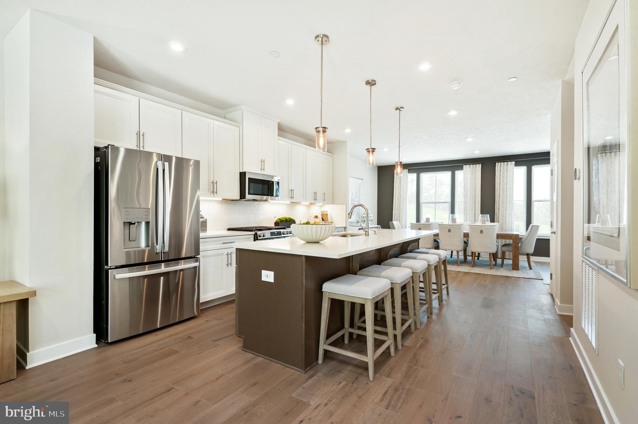 8548 Branch Side Way, Unit B Brandywine, MD 20613 - Photo 3 of 21 a kitchen with stainless steel appliances granite countertop a refrigerator a sink dishwasher a dining table and chairs with wooden floor