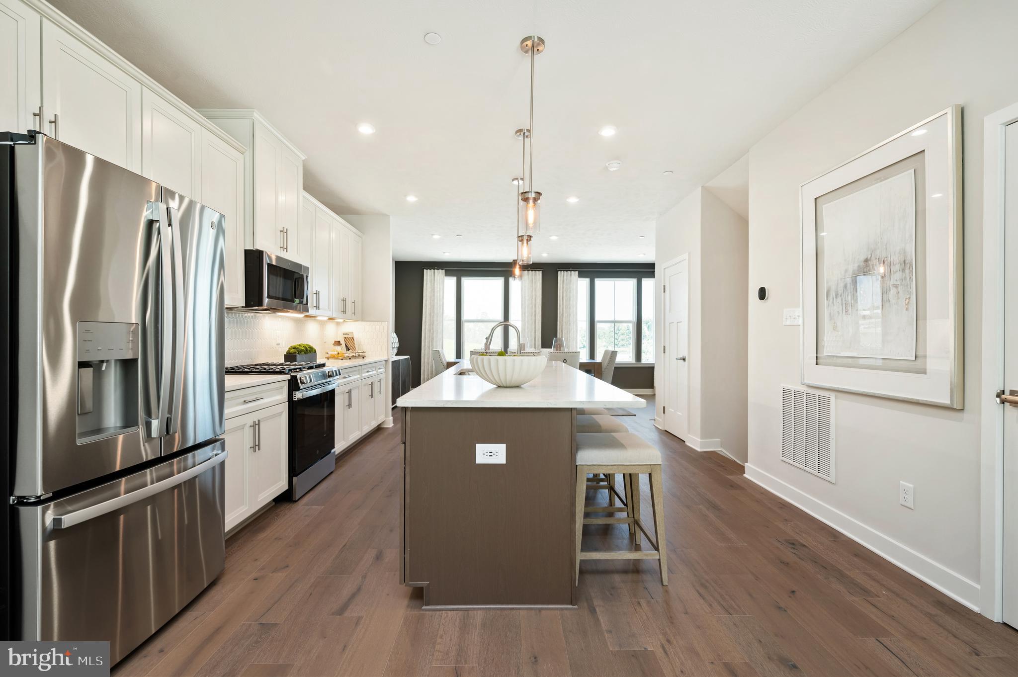 8548 Branch Side Way, Unit B Brandywine, MD 20613 - Photo 4 of 21 a kitchen with kitchen island white cabinets and stainless steel appliances