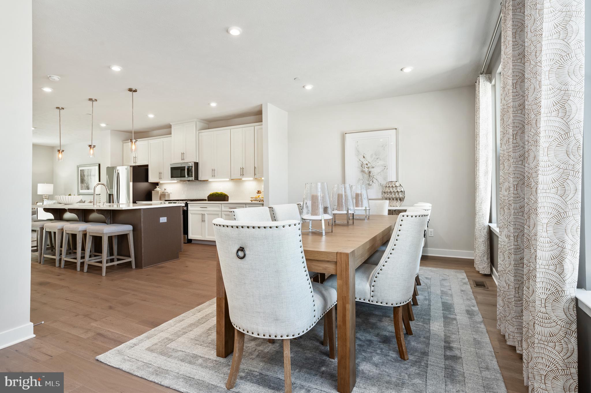 8548 Branch Side Way, Unit B Brandywine, MD 20613 - Photo 5 of 21 a dining room with stainless steel appliances kitchen island granite countertop a sink a stove a dining table and chairs